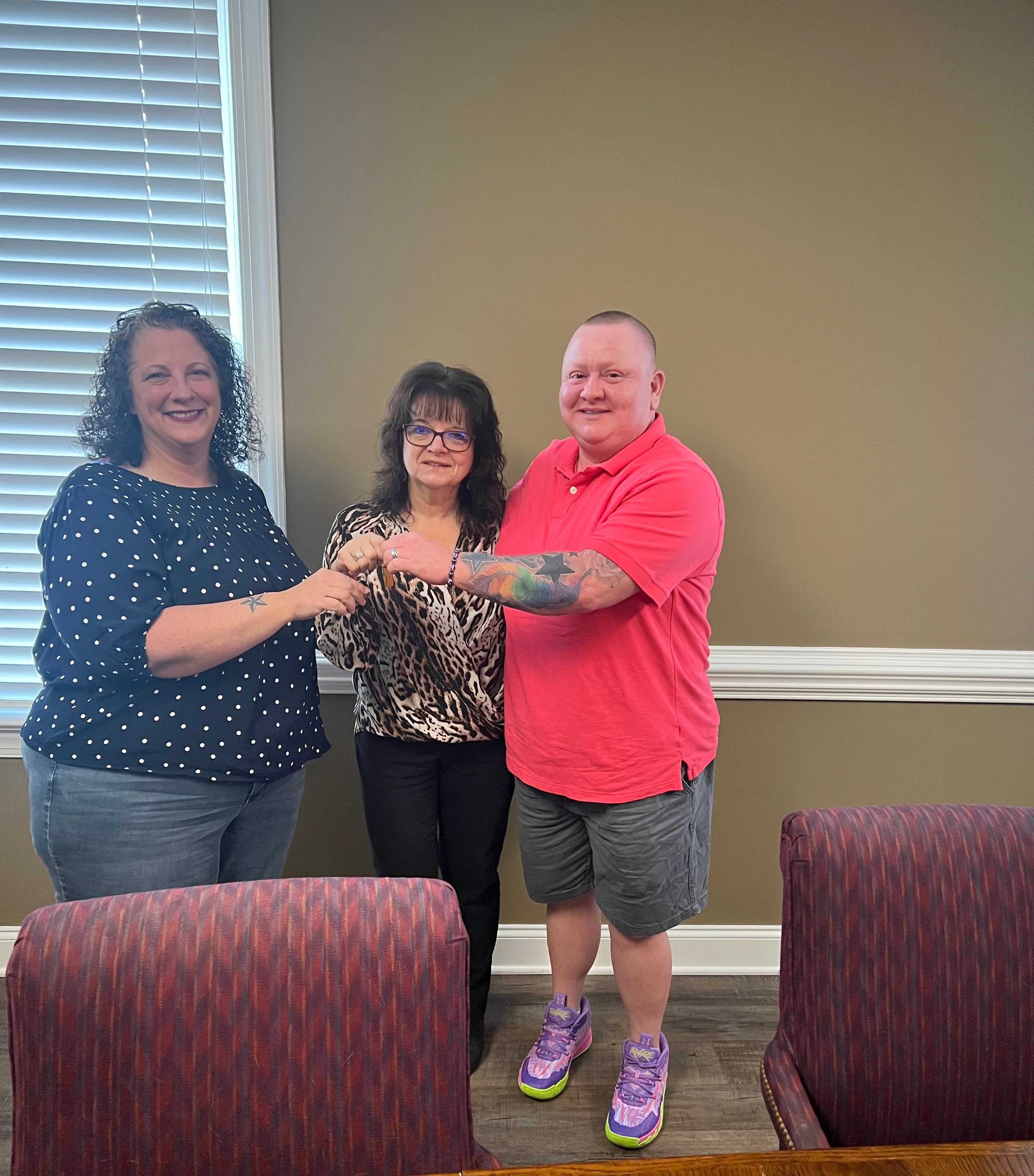 Agent handing keys to happy buyers at the closing table