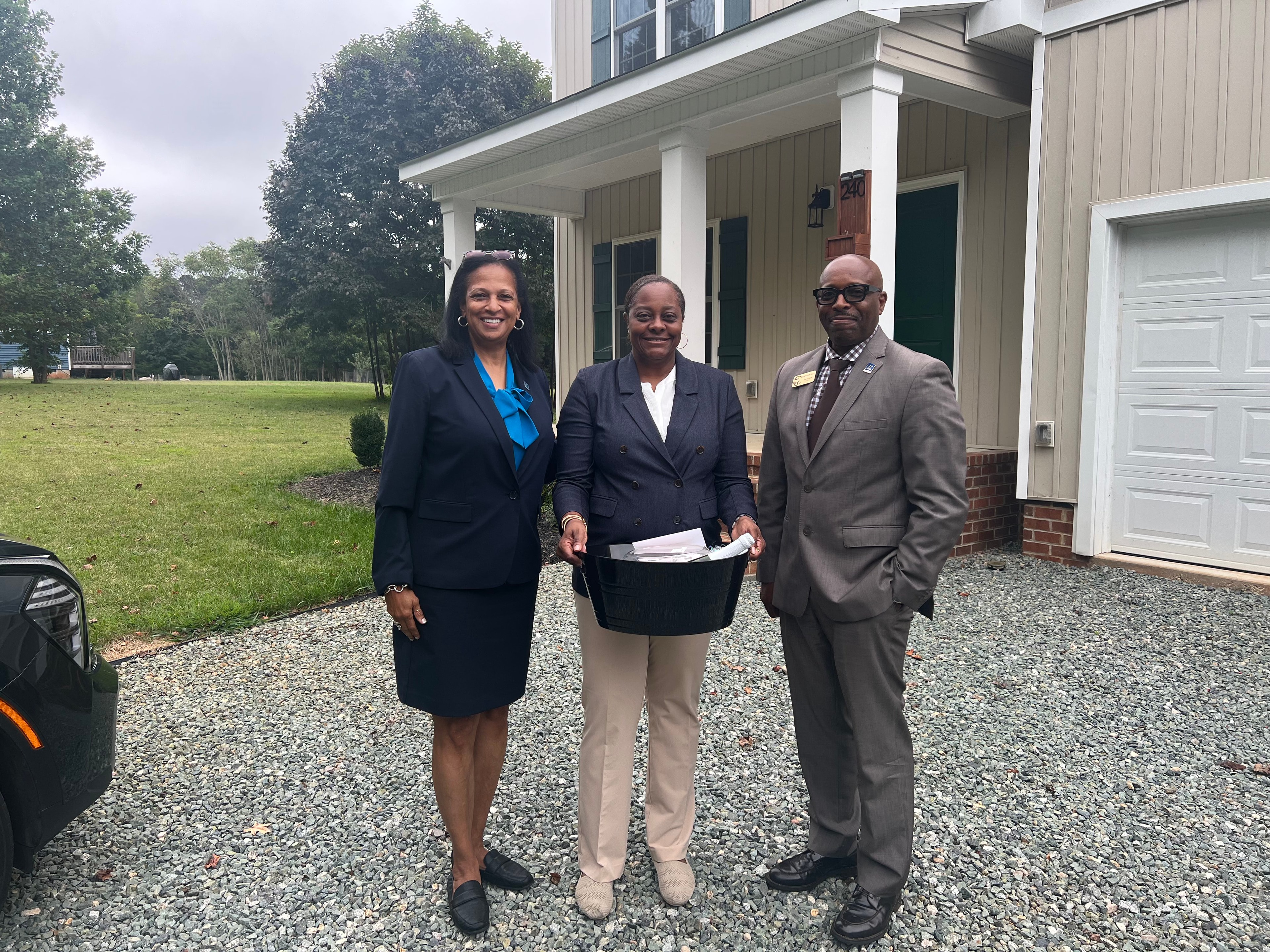 Happy family with We Said Yes to the Address and SOLD signs in front of their new home